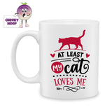 white ceramic mug with the words "At least my cat loves me" together with a picture of the outline of a cat printed on the mug. Mug as produced by Cheekyneep.com