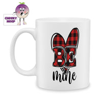 White ceramic mug with a red and black checkered heart shape with the words 