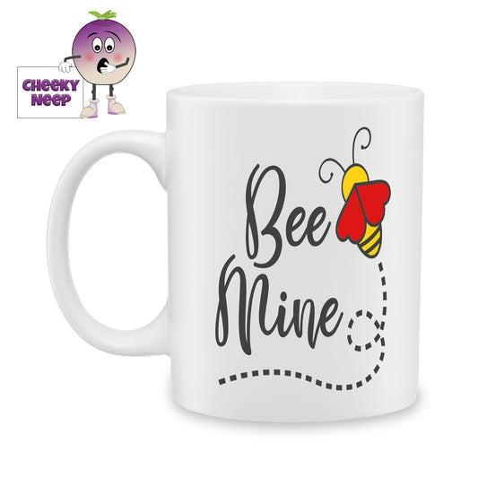 White ceramic mug with the words "Bee mine" and a large bee with two red hearts for wings as produced by Cheekyneep.com