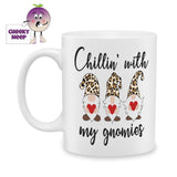 White ceramic mug with three gnomes holding red hearts and the words "Chillin' with my gnomes" printed on the mug as produced by Cheekyneep.com