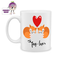 White ceramic mug with a large red heart above two foxes and the words 