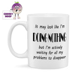 10oz ceramic mug with the text "It may look like I'm DOING NOTHING but I'm actively waiting for all my problems to disappear" printed in black text