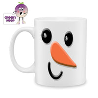 White ceramic mug with the picture of a snowman's smiling face printed on the mug. As produced by Cheekyneep.com