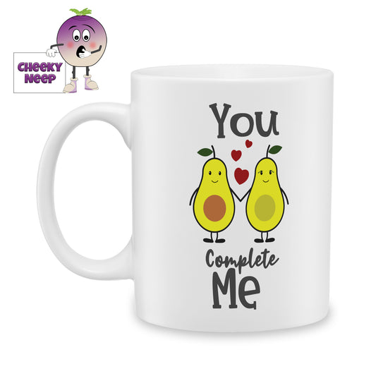 white ceramic mug with a picture of two halves of an avocado holding hands and the words "You Complete Me" printed on the mug. Mug as produced by Cheekyneep.com