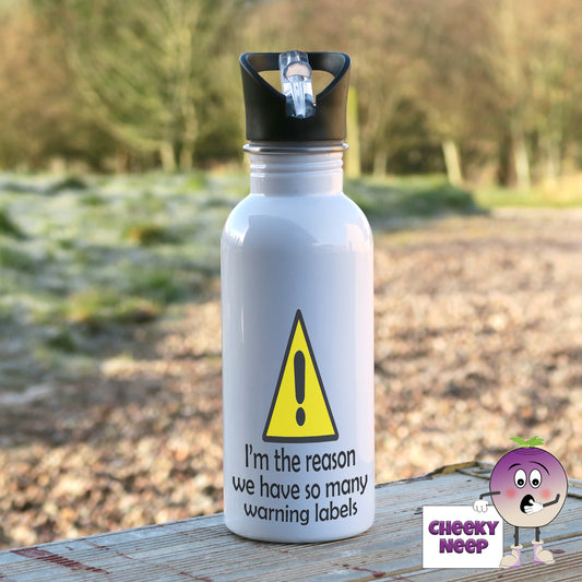 600ml white aluminium sports water bottle with a yellow triangle and black exclamation mark printed on the bottle. Below the yellow triangle is text in black "I'm the reason we have so many warning labels"