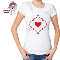 Woman in a white tee with an arabesque outline with a red heart in the middle printed on the tee. Tee as produced by Cheekyneep.com