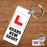Rectangular plastic keyring with the words "Brand New Daddy" printed on both sides.