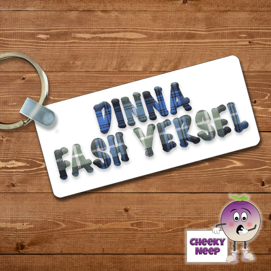 Rectangular plastic keyring with the words "Dinna Fash Yersel" printed in a tartan font on both sides.