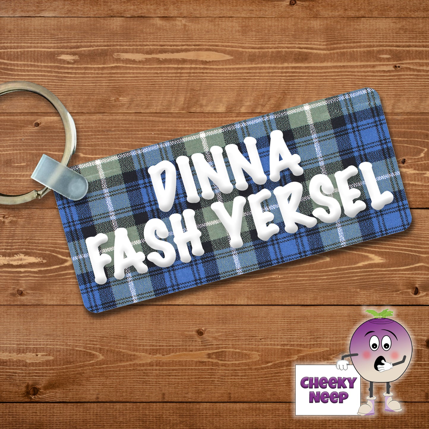 Rectangular plastic keyring with the words "Dinna Fash Yersel" printed on both sides in a white font on a tartan background.