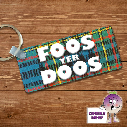 Rectangular plastic keyring with the words "Foos yer Doos" printed in white on a tartan background on both sides.