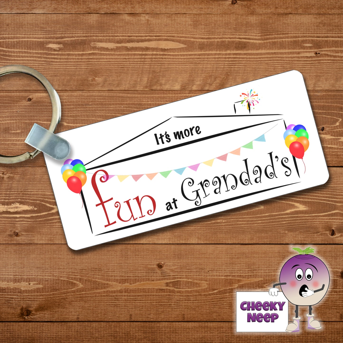 Rectangular keyring with the slogan "It's more fun at Grandad's" printed within the silhoutte of a house with coloured balloons and bunting and fireworks coming out of the chimney