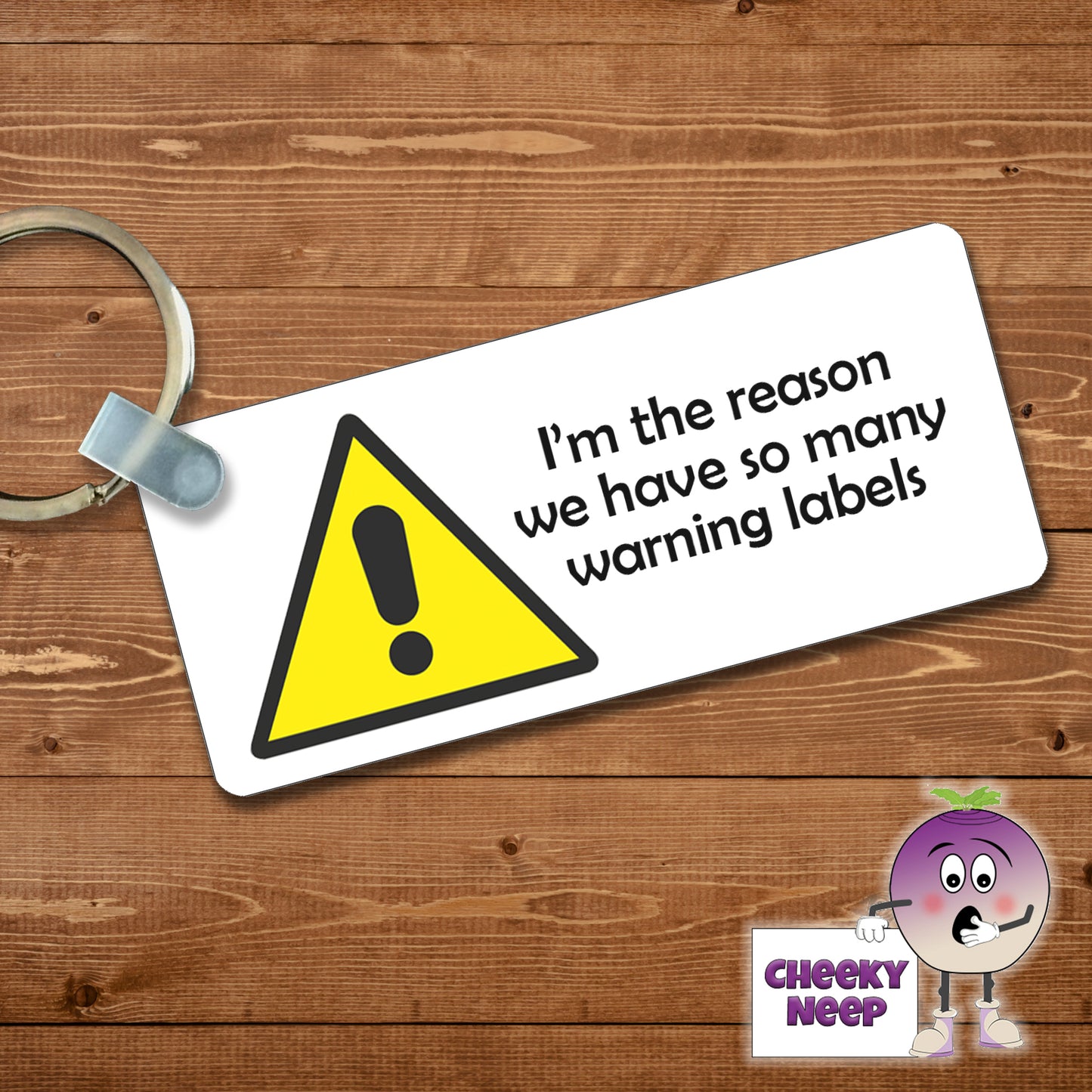 Rectangular plastic keyring with the words "I'm the reason we have so many warning labels" printed on both sides.