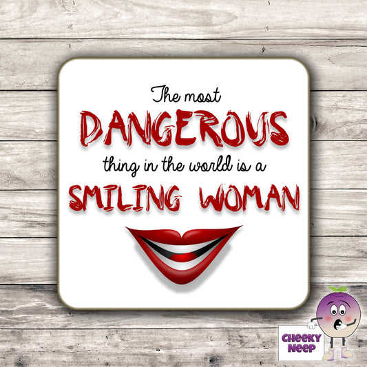 Square hardbacked coaster with the words "The most DANGEROUS thing in the world is a SMILING WOMAN" printed on it.