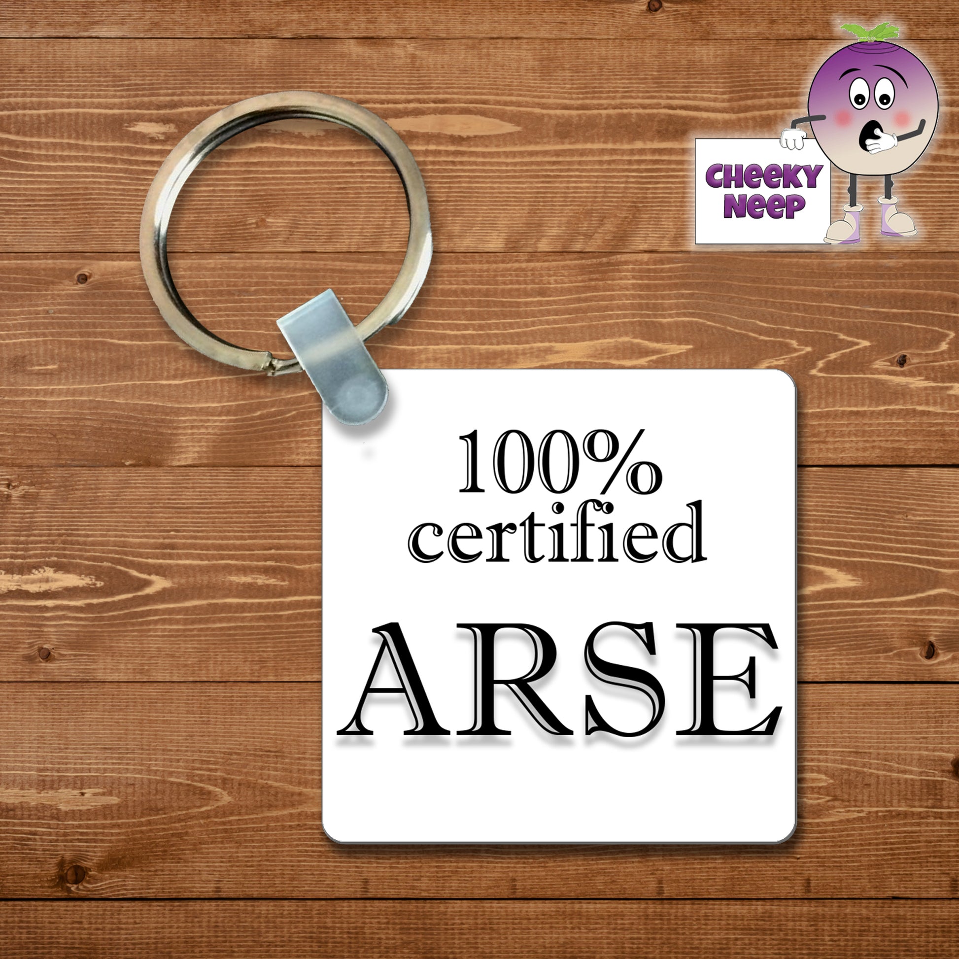 Square plastic keyring with the words "100% Certified Arse" printed on both sides.