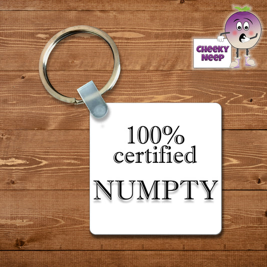 Square plastic keyring with the words "100% Certified Numpty" printed on both sides.