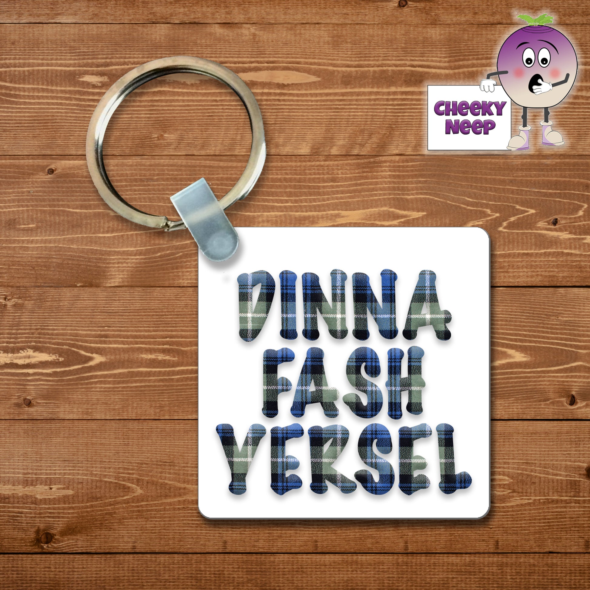 Square plastic keyring with the words "Dinna Fash Yersel" printed on both sides in blue tartan.