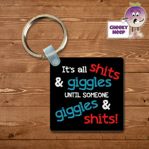 Black square keyring with "It's all shits & giggles until someone giggles & shits!"  printed on the keyring as supplied by Cheekyneep.com