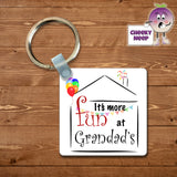 Square keyring with the slogan "It's more fun at Grandad's" printed inside the outline of a house with some coloured balloons and bunting and fireworks coming out of the chimney