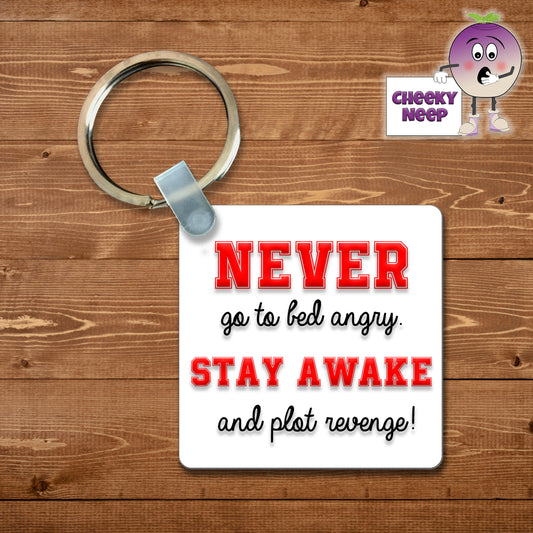 Square plastic keyring with the words "Never go to bed angry Stay awake and plot revenge!" printed on both sides.