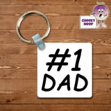 Square plastic keyring with the words "#1 Dad" printed on both sides.
