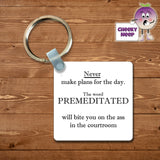 Square plastic keyring with the words "Never make plans for the day. The word PREMEDITATED will bite you on the ass in the courtroom" printed on both sides.