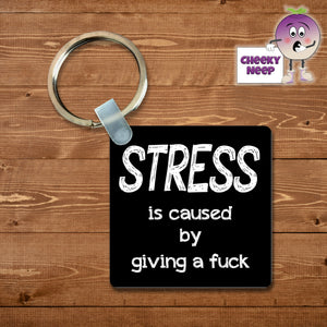 Square black keyring with the words "Stress is caused by giving a fuck"  printed on the keyring as supplied by Cheekyneep.com