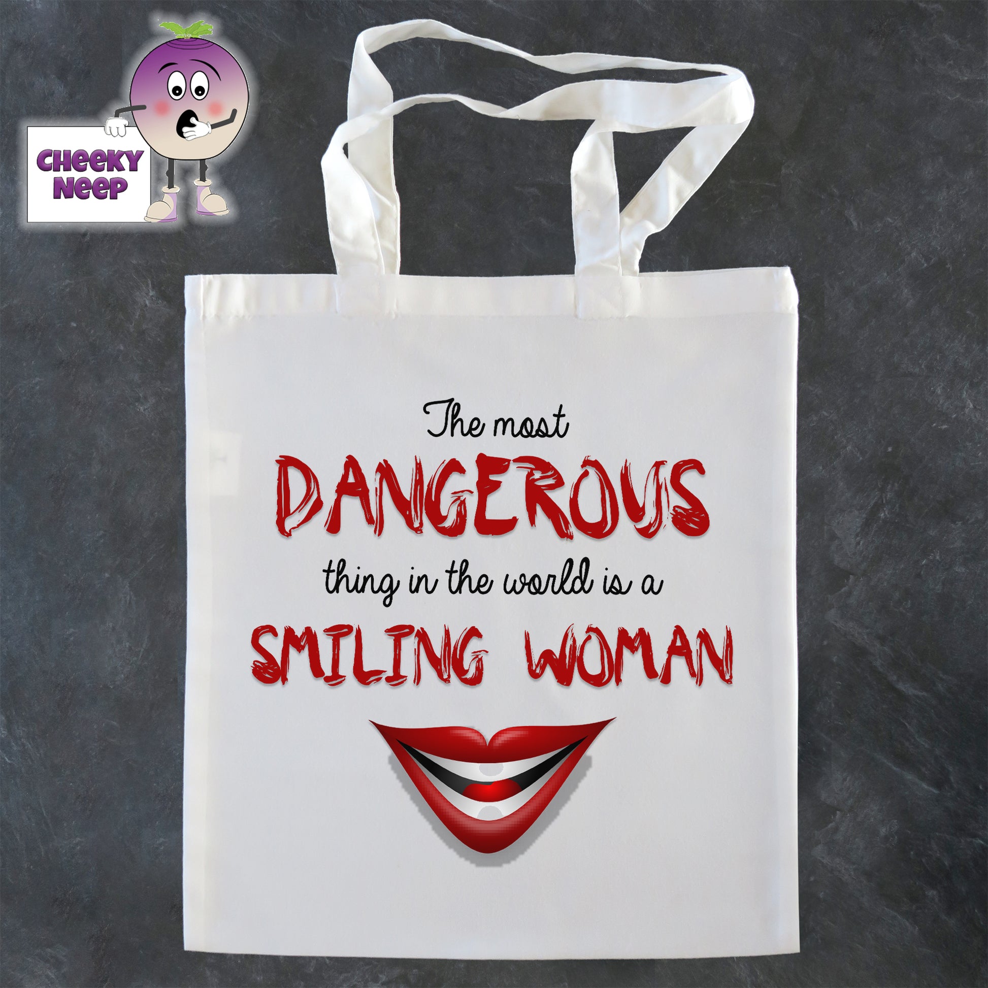 Tote Shopping bag in white with the words "The most DANGEROUS thing in the world is a SMILING WOMAN" printed on the bag